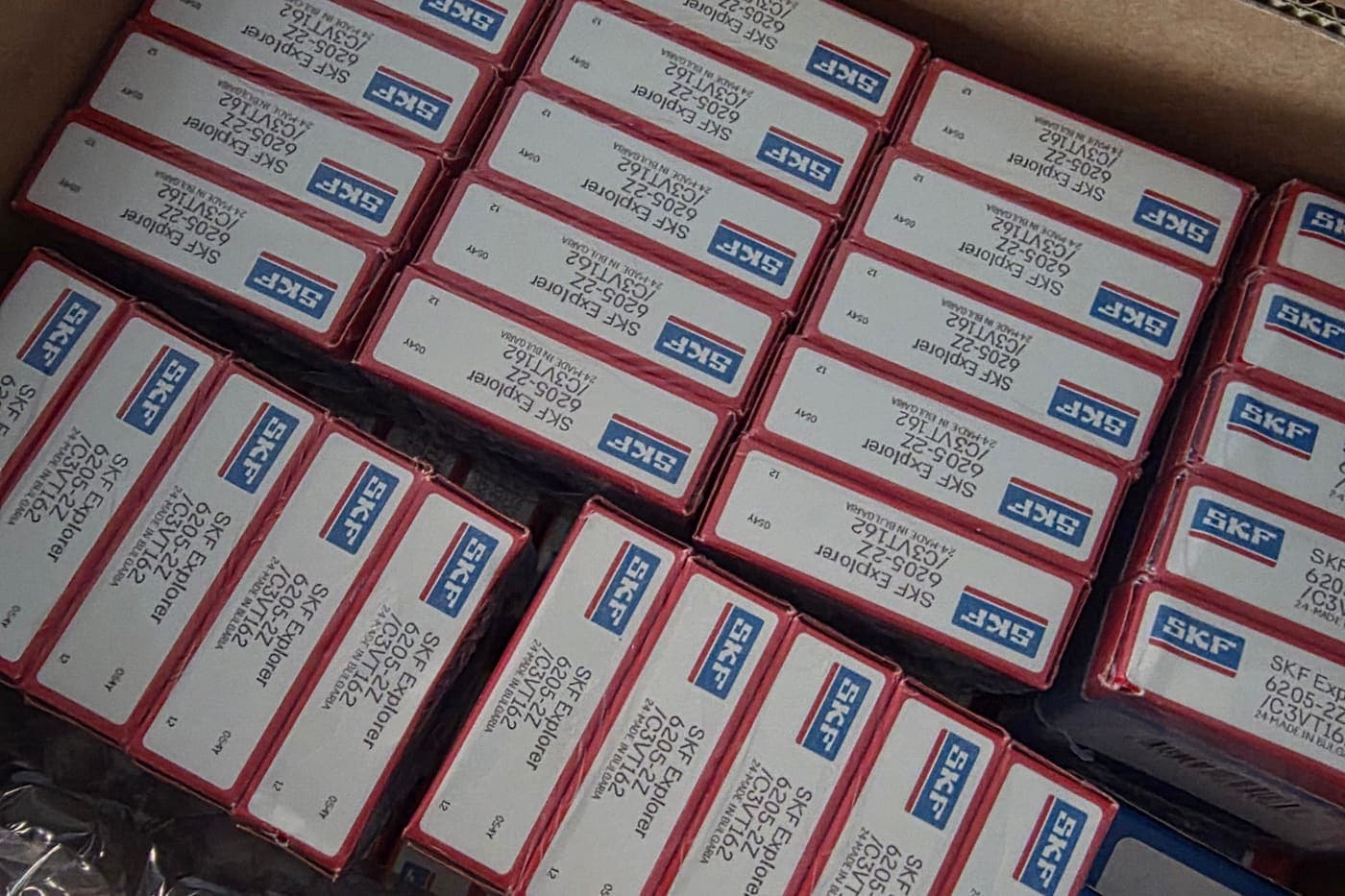 Kartonnen doos gevuld met SKF Explorer-lagers in hun rode verpakking, klaar om te verzenden